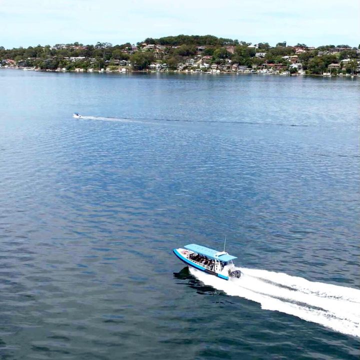 A boat travels fast along the water in Lake Macquarie