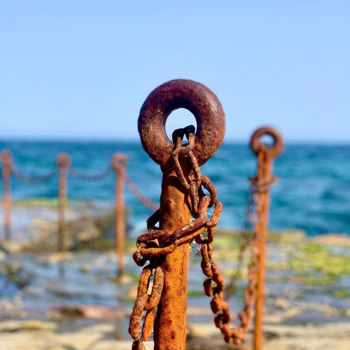 A rusted railing surrounding an ocean pool